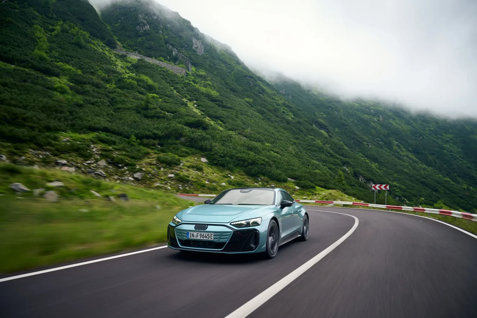 Light green Audi e-tron GT on a mountain bend.