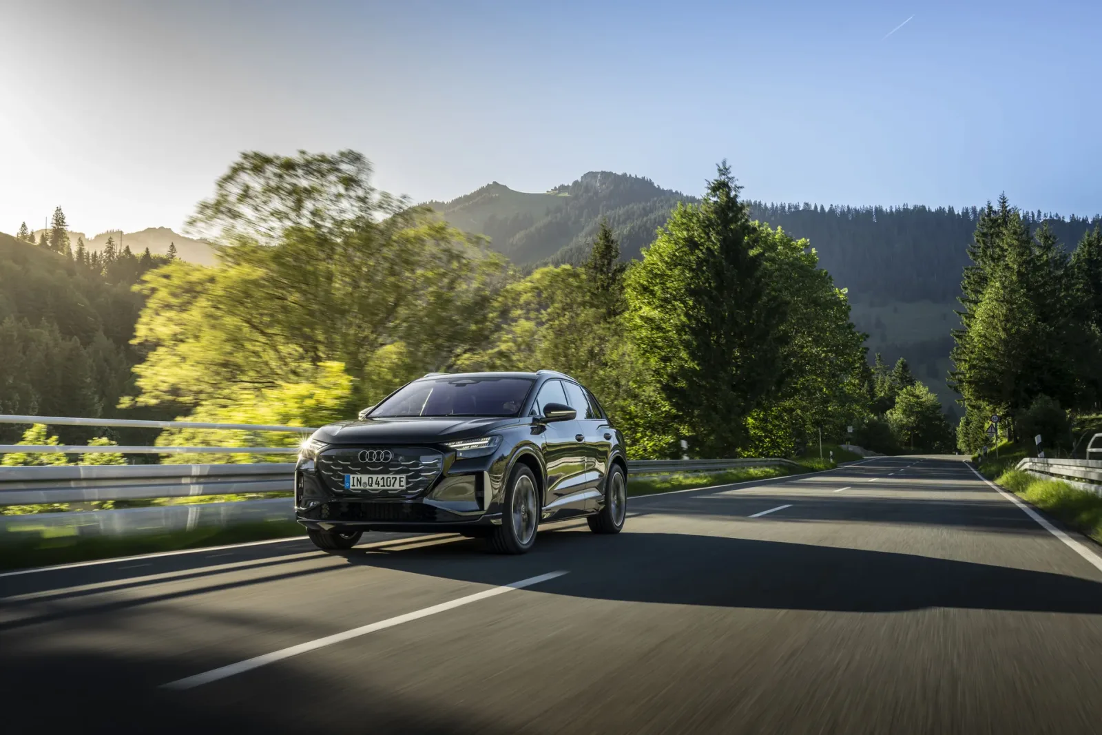 Grey Audi Q4 e-tron, front three-quarter view on a mountain road.