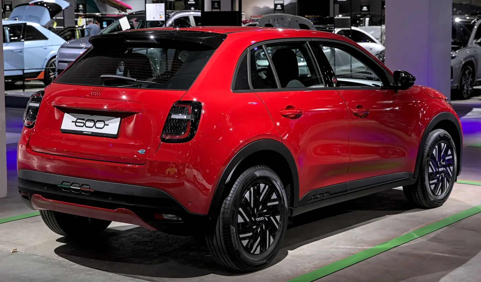 Red Fiat 600e in rear three-quarter view.